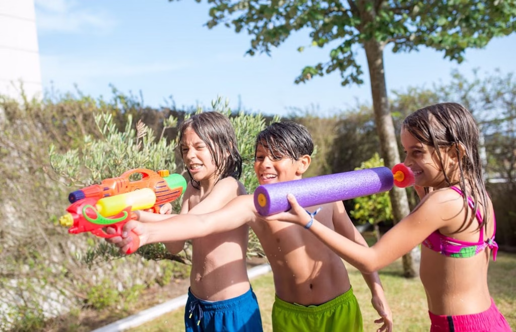 троє дітей 10-12 років грають на вулиці з водою